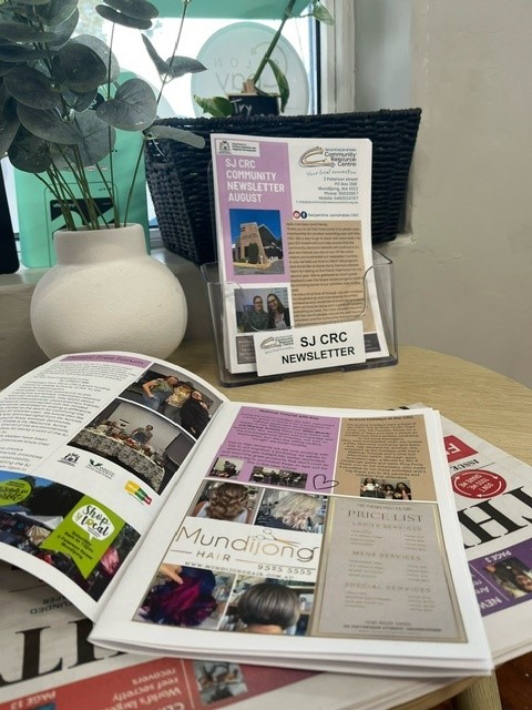Newsletter next to a plant and open on a table